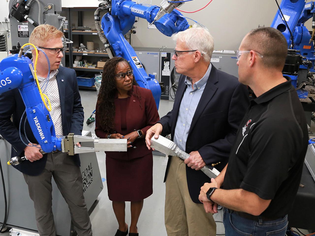 Four people conversing at the Center for Design and Manufacturing Excellence (CDME)
