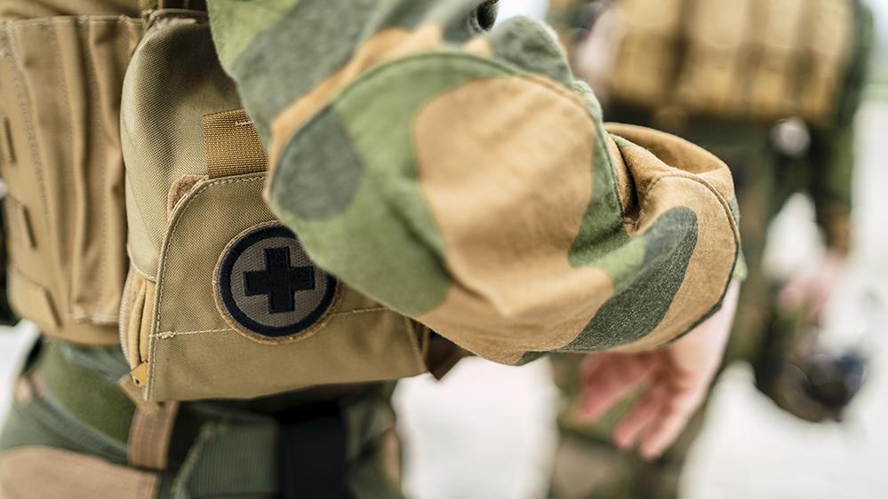 A closeup of a small first aid bag on the uniform of a special force soldier