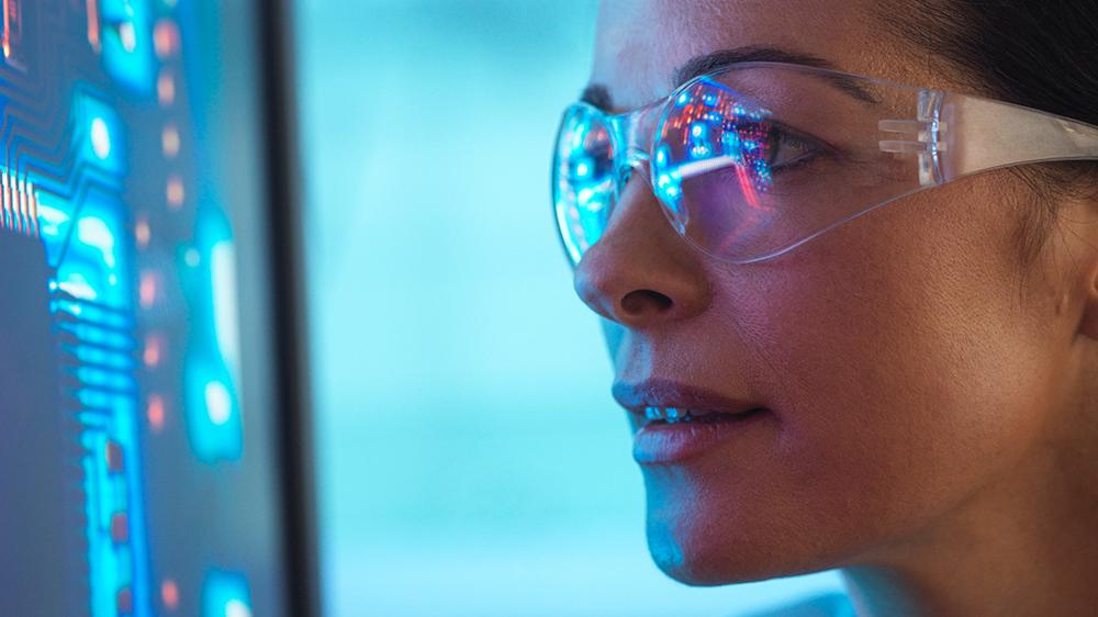 Scientist in glasses looking at screen