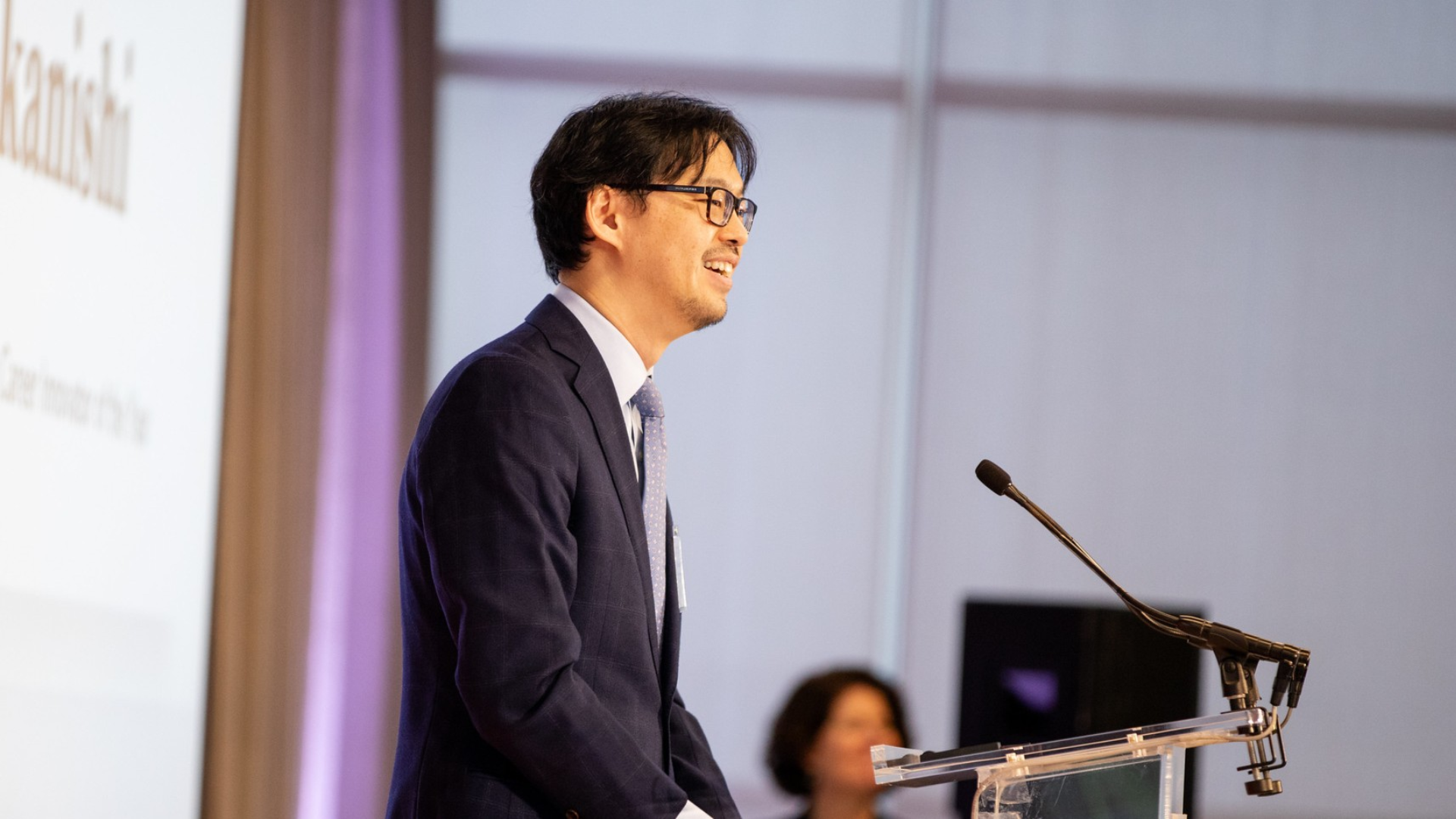 man speaking at podium about his startup