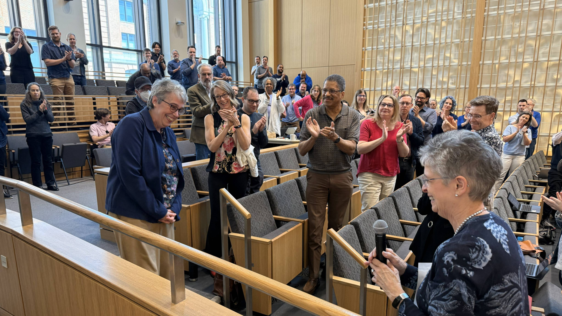 room of colleagues applauding for a woman