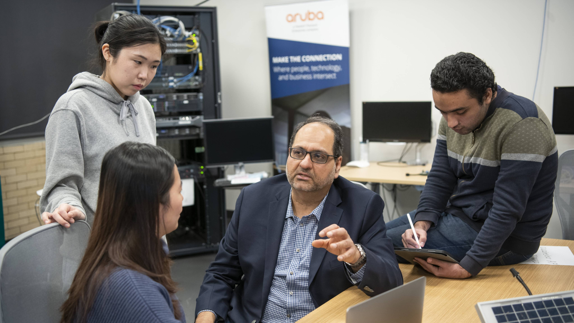 man talking to three students